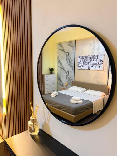 a bedroom with a large round mirror over a bed at Suite la Ficara in Bovalino Marina