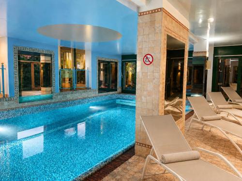 a swimming pool with lounge chairs in a building at Villa Spa Chiara Luna by Lago Reisen in Oggebio