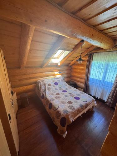 a bedroom with a bed in a wooden cabin at Cabana Bocus in Păltinoasa