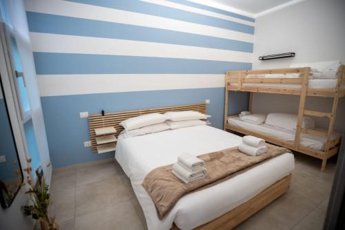 a bedroom with two bunk beds and blue and white stripes at Bilo 66 in Palmi