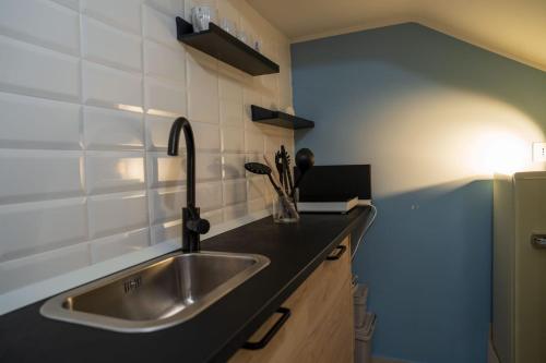 a kitchen with a sink and a black counter top at Bilo 66 in Palmi