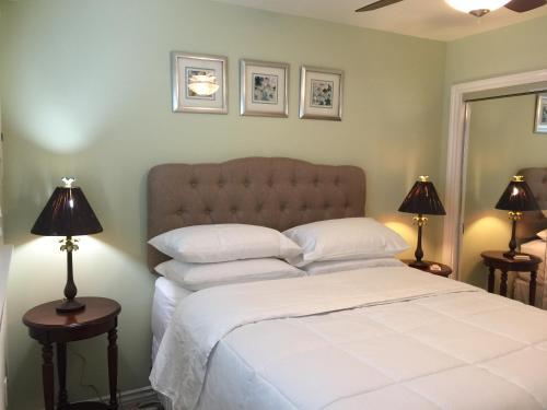 a bedroom with a large white bed with two lamps at The Beach Palms Carlsbad in Carlsbad