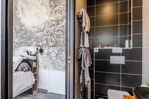a bathroom with a shower with black tiles at Tomland in Parentis-en-Born