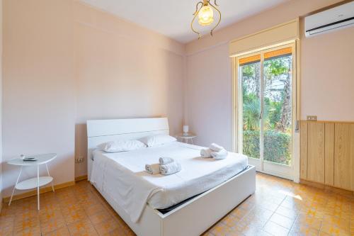 a bedroom with a white bed with towels on it at Villa Preside in Noto Marina