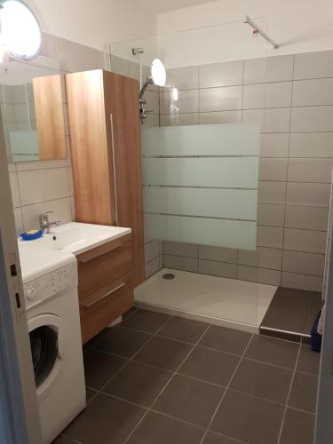 a bathroom with a sink and a washing machine at SUPERBE VUE sur la MER in Le Grau-dʼAgde