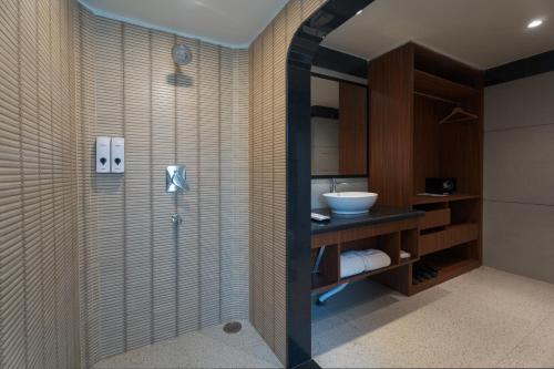 a bathroom with a shower and a sink at Summit Green Lake Tea Resort & Spa in Jakhalābāndha