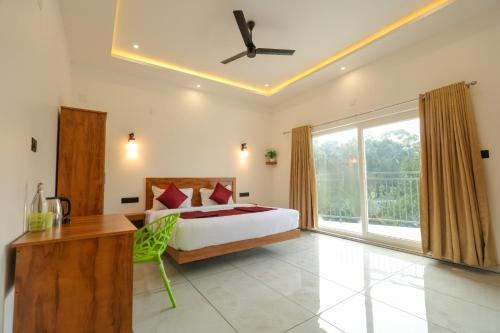 a bedroom with a bed and a large window at Rivendell resort Munnar in Munnar