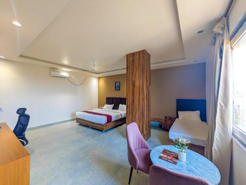 a hotel room with two beds and a table at Hotel Aashiyana in Shahdol