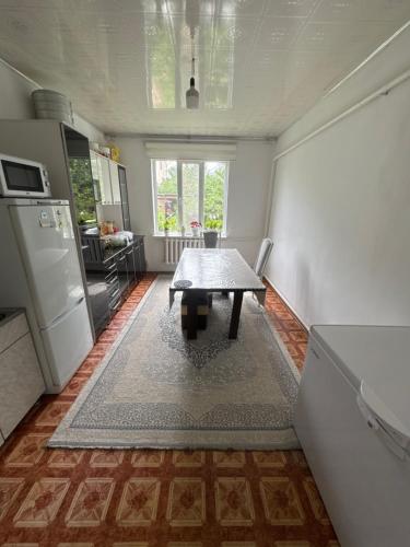 a kitchen with a table in the middle of a room at Дом in Bishkek
