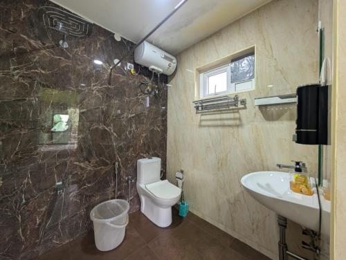 a bathroom with a toilet and a sink at Moonlight Chillers By LexStays in Yedapalli