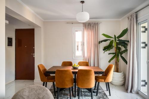 a dining room with a wooden table and chairs at Althaia Three-Bedroom Maisonette by Konnect in Corfu