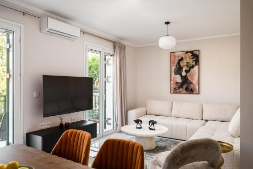 a living room with a couch and a tv at Althaia Three-Bedroom Maisonette by Konnect in Corfu