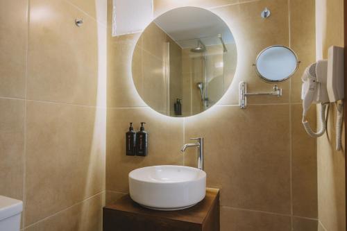 a bathroom with a sink and a mirror at Casa Di Notos Beach Hotel - Georgioupolis in Georgioupolis