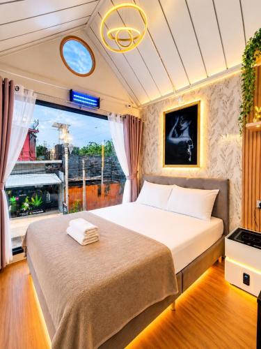 a bedroom with a bed and a large window at NearBKKHomestayAirport in Bang Phli