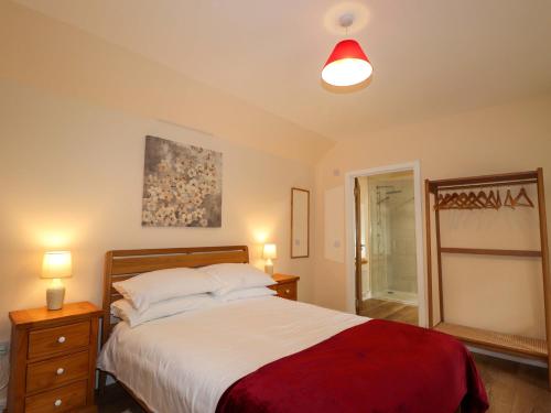 a bedroom with a bed and two night stands and two lamps at Laundry Cottage in Strathpeffer