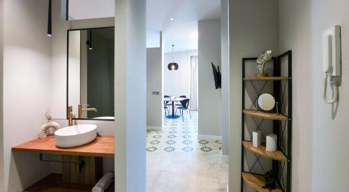 a bathroom with a tub and a sink and a mirror at Heritage apartamentos in Villajoyosa