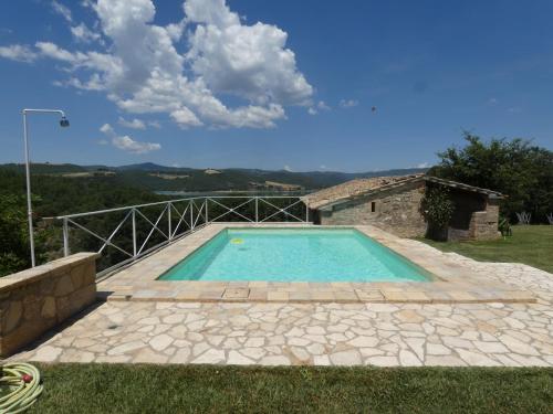 a swimming pool in a yard with a house at SCAPPO IN UMBRIA, casale al lago in Corbara