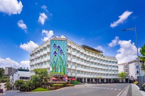 a building with a mural on the side of it at Nesta Valley Dalat Hotel - Formerly Golf Valley Hotel in Da Lat