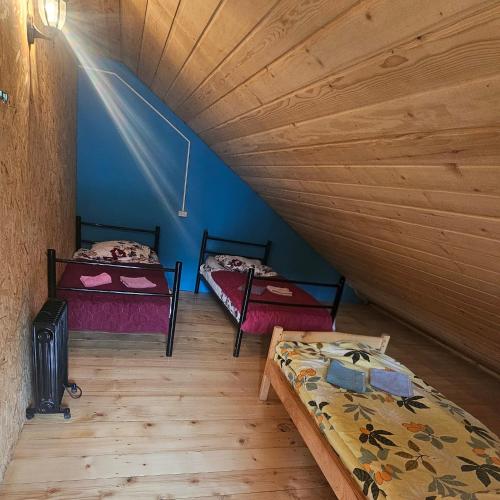 two beds in a room with blue walls and wooden floors at Elo's Guesthouse in Iprari