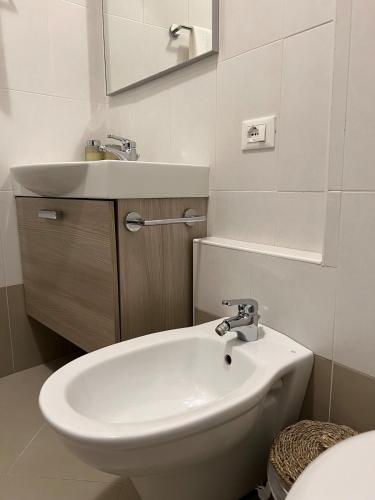 a white bathroom with a sink and a toilet at Ottanio 2 Lake Apartments in Pisogne