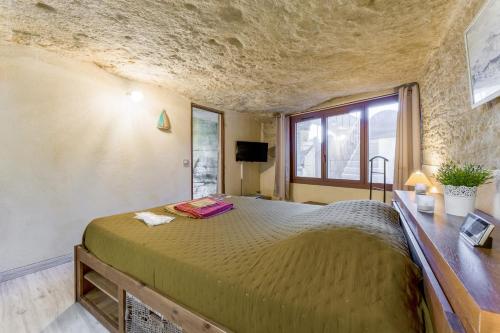 a bedroom with a large bed and a window at Studio Troglodyte en Provence in Cornillon-Confoux