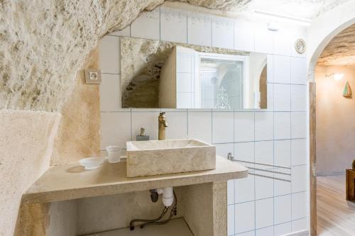 a bathroom with a sink and a stone wall at Studio Troglodyte en Provence in Cornillon-Confoux