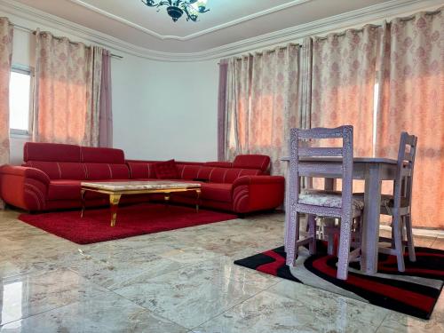 a living room with a red couch and a table at L Arche in Douala