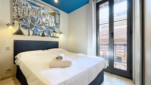 a bedroom with a bed with a bag on it at Hotel Le Florian in Cannes