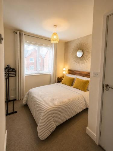 a bedroom with a bed with yellow pillows and a window at Mason Gardens Home in Chilton