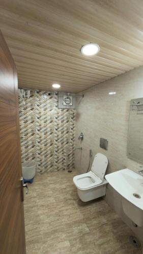 a bathroom with a toilet and a sink at YogMaya Regency in Shimla