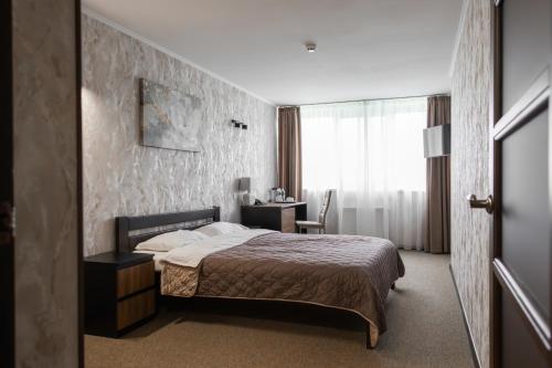 ein Schlafzimmer mit einem Bett und einem Schreibtisch in der Unterkunft Cherkasy Palace in Tscherkassy