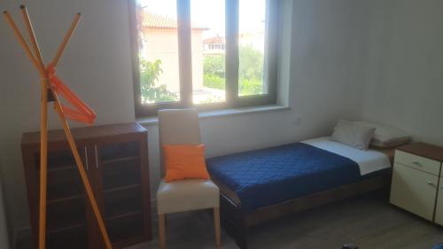 a bedroom with a bed and a chair and a window at Eco-Luxury Suite Luna in Umag