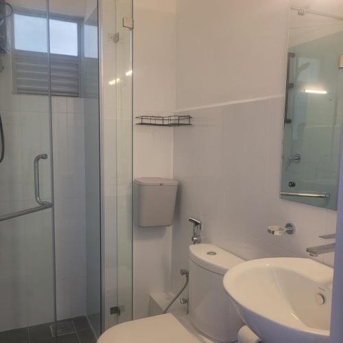 a white bathroom with a toilet and a sink at Inverse Travels in Negombo