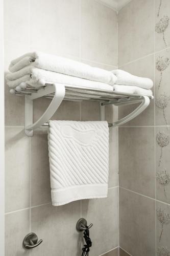 ein Handtuchhalter in einem Badezimmer mit weißen Handtüchern in der Unterkunft Cherkasy Palace in Tscherkassy