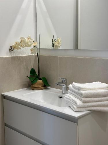 a bathroom sink with white towels and a mirror at Dimora di Aida Lugano Lake in Porlezza