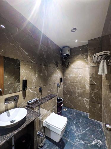 a bathroom with a white toilet and a sink at Hotel Aashiyana in Shahdol