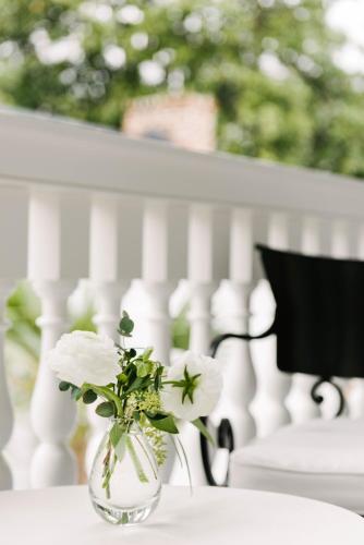 a vase with white flowers sitting on a table at 86 Cannon Charleston - Adults Only in Charleston