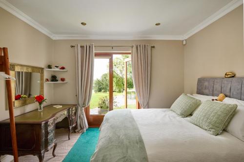 a bedroom with a bed and a desk and a window at 2 Bedroom Apartment - Free Parking & Garden in Kilmessan