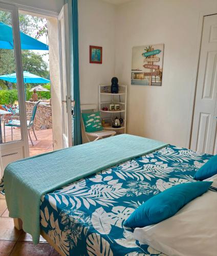 a bedroom with a bed with a blue and white blanket at Villa des Delices in Grimaud
