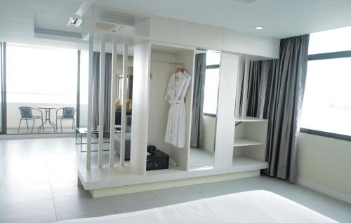 a dressing room with a white robe on a rack at Hermann Hotel Pattaya in Pattaya