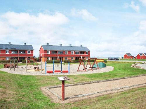 a playground in front of a red building at 5 person holiday home on a holiday park in Lemvig in Lemvig