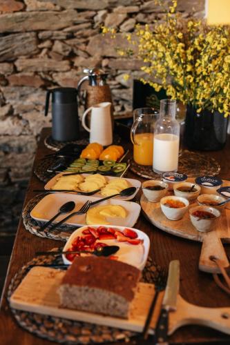 a wooden table with plates of food on it at Herdade dos Abegões in Salvaterra do Extremo
