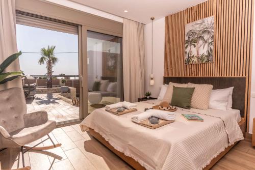 a bedroom with a large bed and a chair at 3 Muses Luxury Villas in Kalamaki
