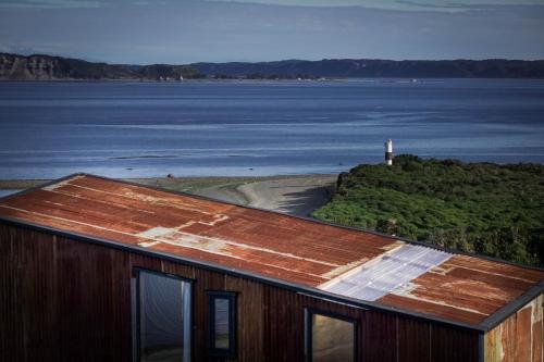 a building with a view of a body of water at El Coo Lodge in Queilén