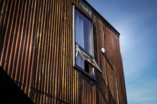 a window on the side of a wooden building at El Coo Lodge in Queilén