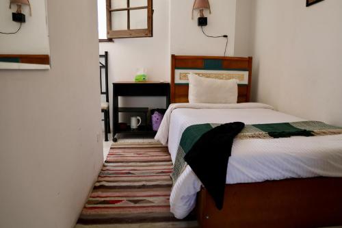 a bedroom with a bed and a table with a window at A private room by the rooftop in Cairo