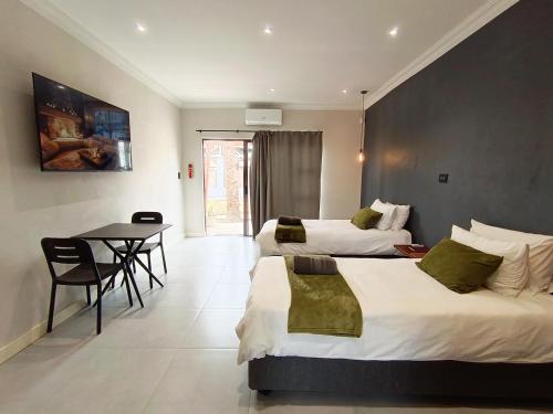 a hotel room with two beds and a table at Unit 7 Dinas Accommodation Oranjemund in Oranjemund