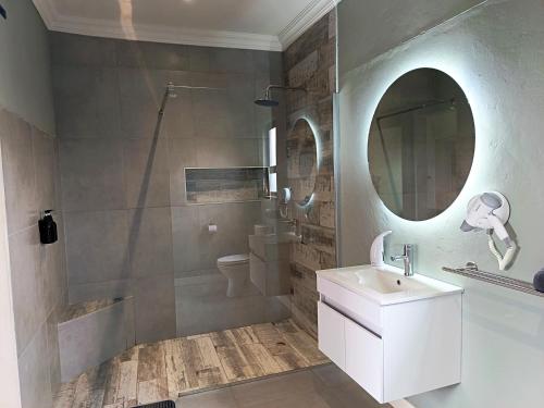 a bathroom with a shower and a sink and a mirror at Unit 7 Dinas Accommodation Oranjemund in Oranjemund