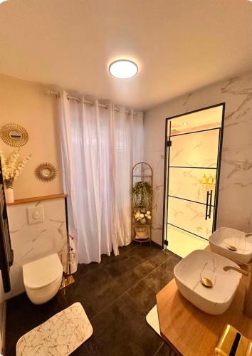 a bathroom with two toilets and a large window at Secret Rock - Jaccuzi privé in La-Roche-en-Ardenne