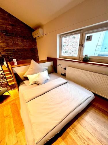 a large white bed in a room with a window at zons22 Tiny Loft in Historic Zons - between Cologne & Düsseldorf in Dormagen